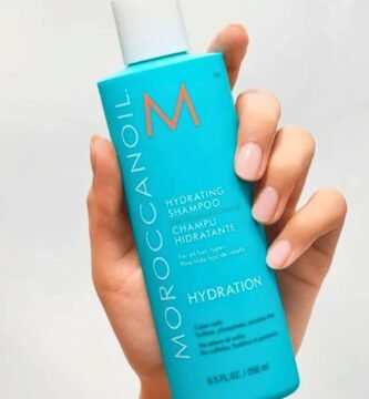 Botella del champú hidratante Moroccanoil con aceite de argán en una mano