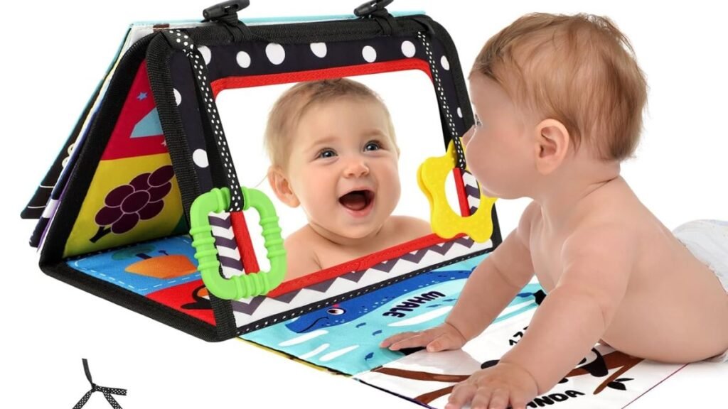 bebé jugando durante tummy time con libro sensorial montessori y espejo plegable.