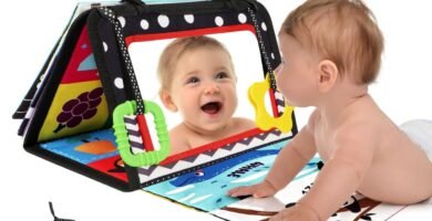 bebé jugando durante tummy time con libro sensorial montessori y espejo plegable.