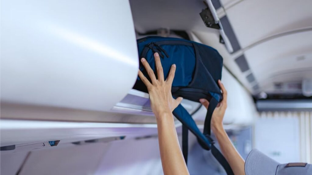 Persona guardando mochila de cabina en avión para viajar sin facturar equipaje