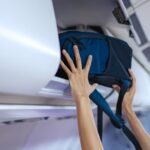 Persona guardando mochila de cabina en avión para viajar sin facturar equipaje