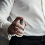 Persona aplicándose perfume en un frasco para ilustrar perfumes con feromonas