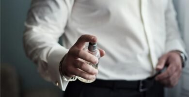 Persona aplicándose perfume en un frasco para ilustrar perfumes con feromonas