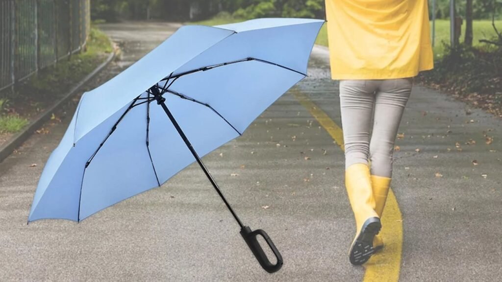 Paraguas grande antiviento volcado por fuertes ráfagas en una carretera mojada durante una tormenta