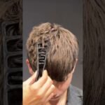 Joven utilizando peine texturizador para dar volumen al peinado masculino en casa